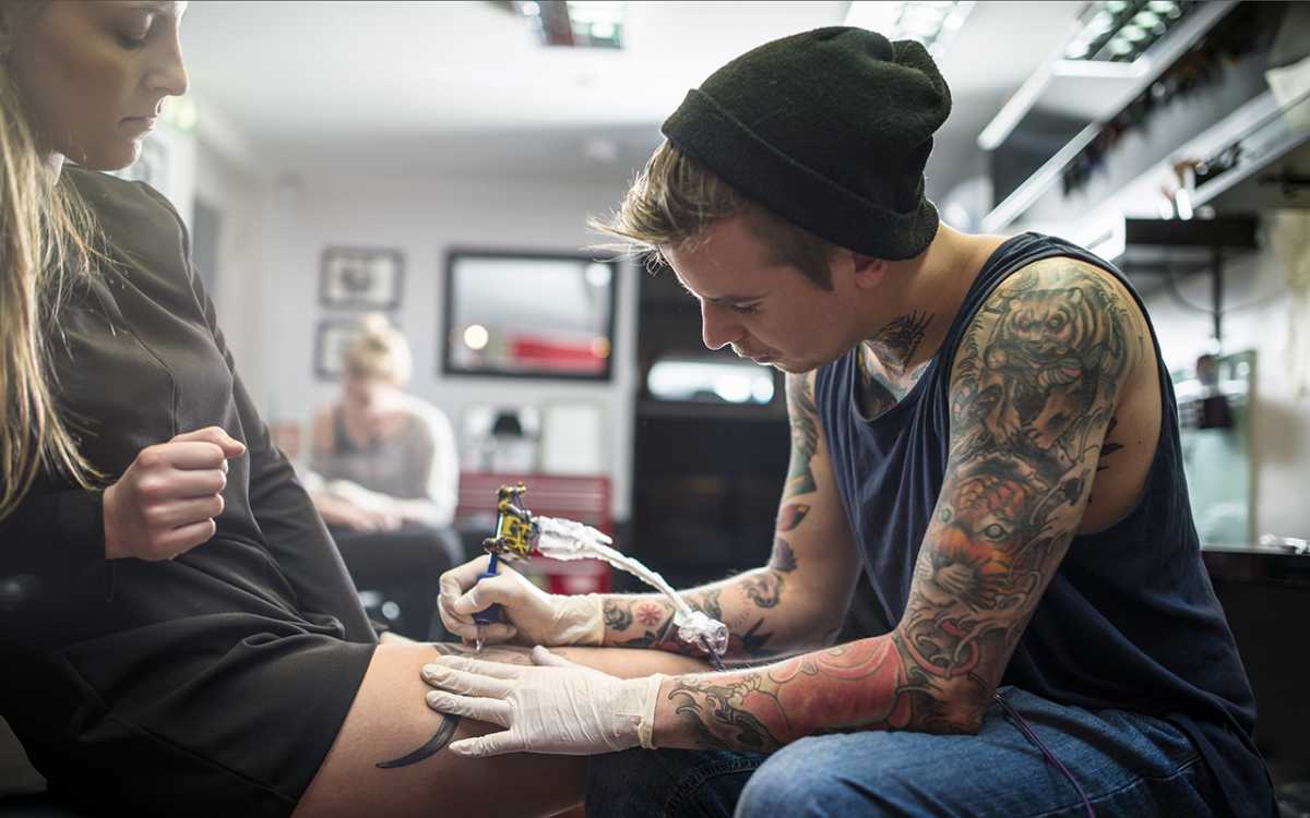 tatuador borrando tatuaje a clienta. foto de reclamador.es, compañía online de reclamaciones