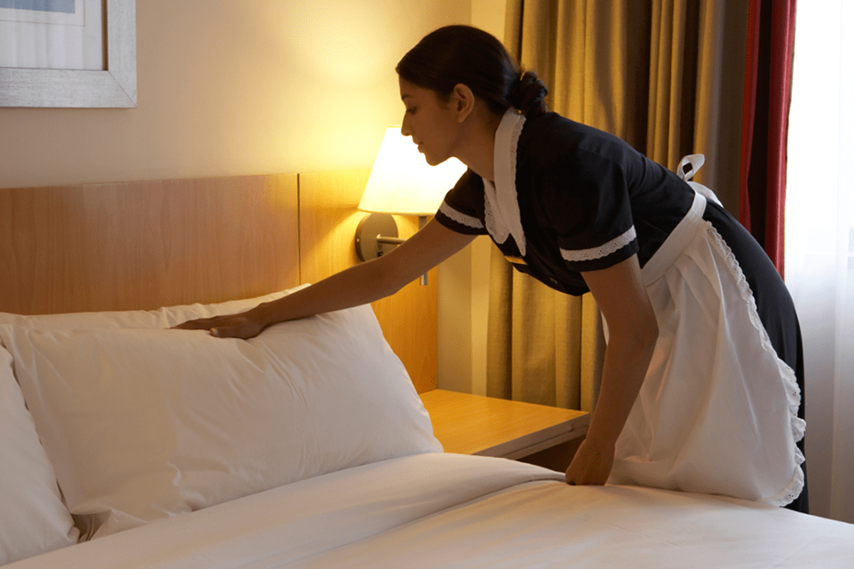 Limpiadora haciendo la cama de un hotel para ilustrar artículo sobre camareras de piso